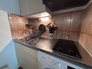 A kitchen with a black stove, a dish rack, and a utensil holder on the counter. - House with parking - 5 guests (Saint-Cyprien)