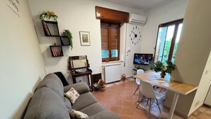 Un soggiorno con divano, tavolo da pranzo e televisore.