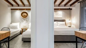 A hotel room with two beds, a small table, a chair, a woven wall hanging, and a ceiling with wooden beams. - Coel Luxury Suites S2 by RentalsPro (Nea Moudania)