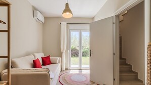 Ein modernes Wohnzimmer mit einer Couch, einem roten Teppich, einer Treppe und einem großen Fenster.