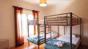 A dormitory room with bunk beds, a window with curtains, and a hanging light fixture. - MyStay - Casa do Carmo (Alvite)