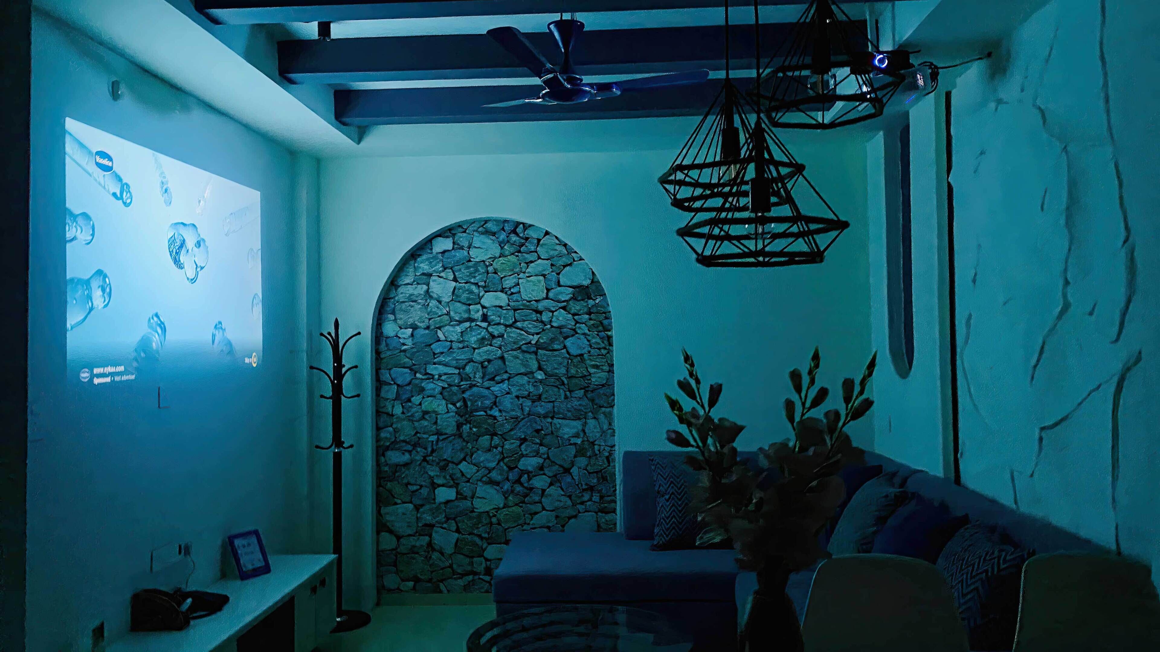 Una stanza con un arco in muratura, un divano, un appendiabiti e una ventola a soffitto.