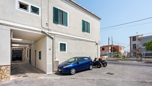Un edificio de dos pisos con un coche estacionado adelante.