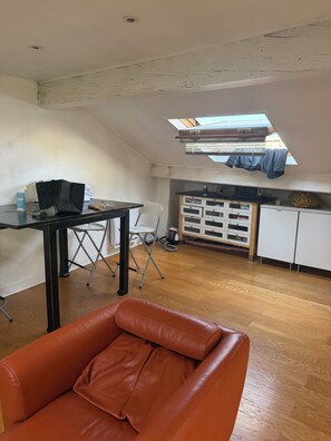 Ein Zimmer mit Schlafkoje, Schreibtisch mit Stuhl, einer kleinen Küchenzeile und einem Oberlicht.