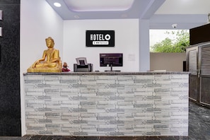 A reception desk with a Buddha statue, a sign reading 'HOTELO,' and a security camera. - Family Rooms With Twin King bed Ravai (Calangute)