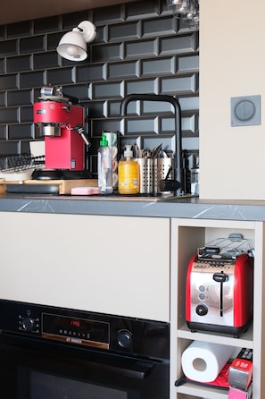 A kitchen with a red coffee machine, a toaster, and a Bosch dishwasher. - Arcachon centre - Studio Cabine superbe vue mer - accès plage (Arcachon)
