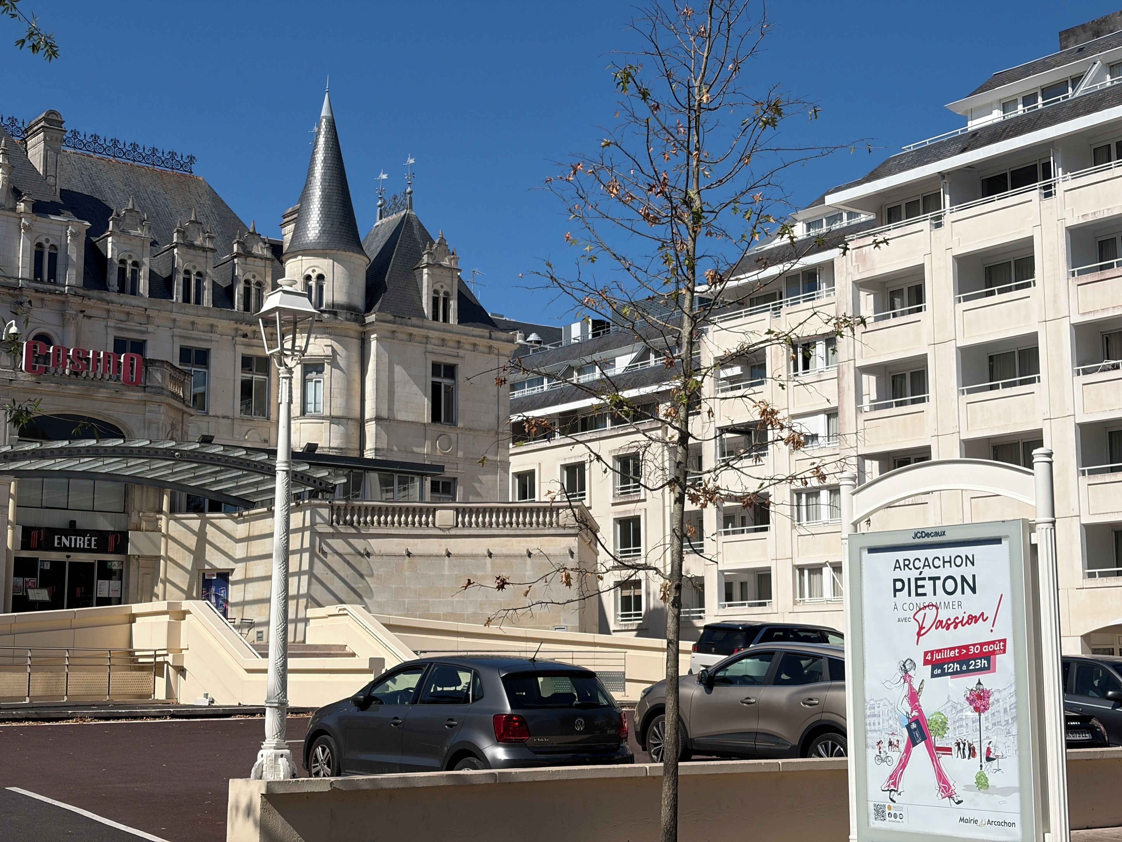 A building with a casino sign, a pedestrian bridge, and a poster advertising an event.