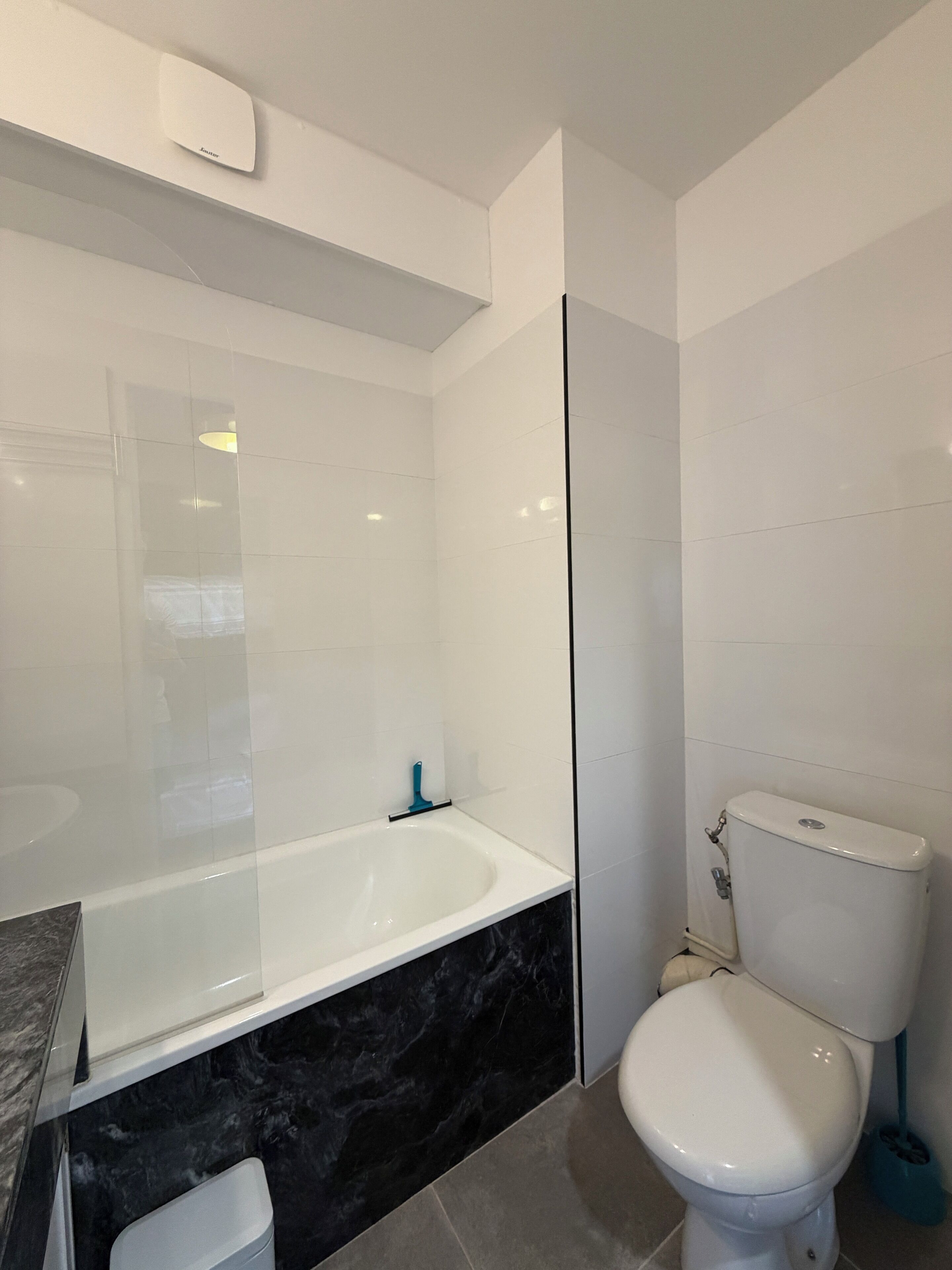 Ein modernes Badezimmer mit einer Badewanne, Toilette und einer Marmorarbeitsplatte.