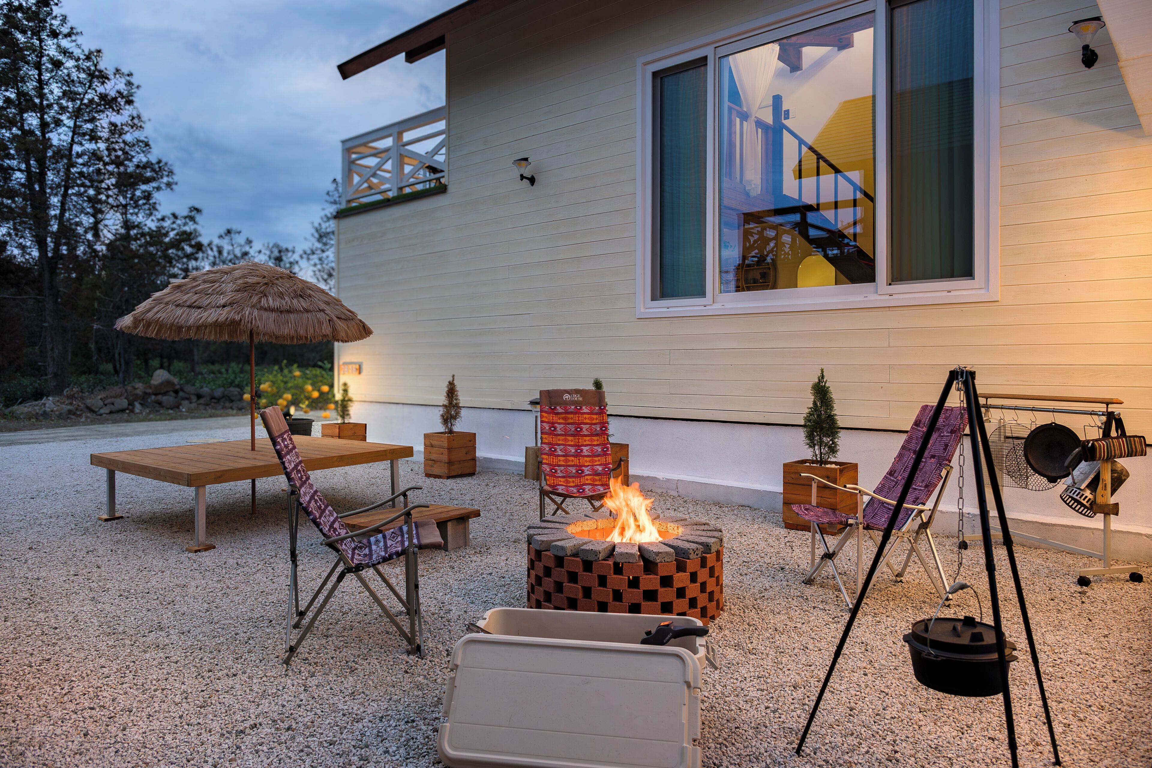 An outdoor seating area with a fire pit, chairs, and a table.