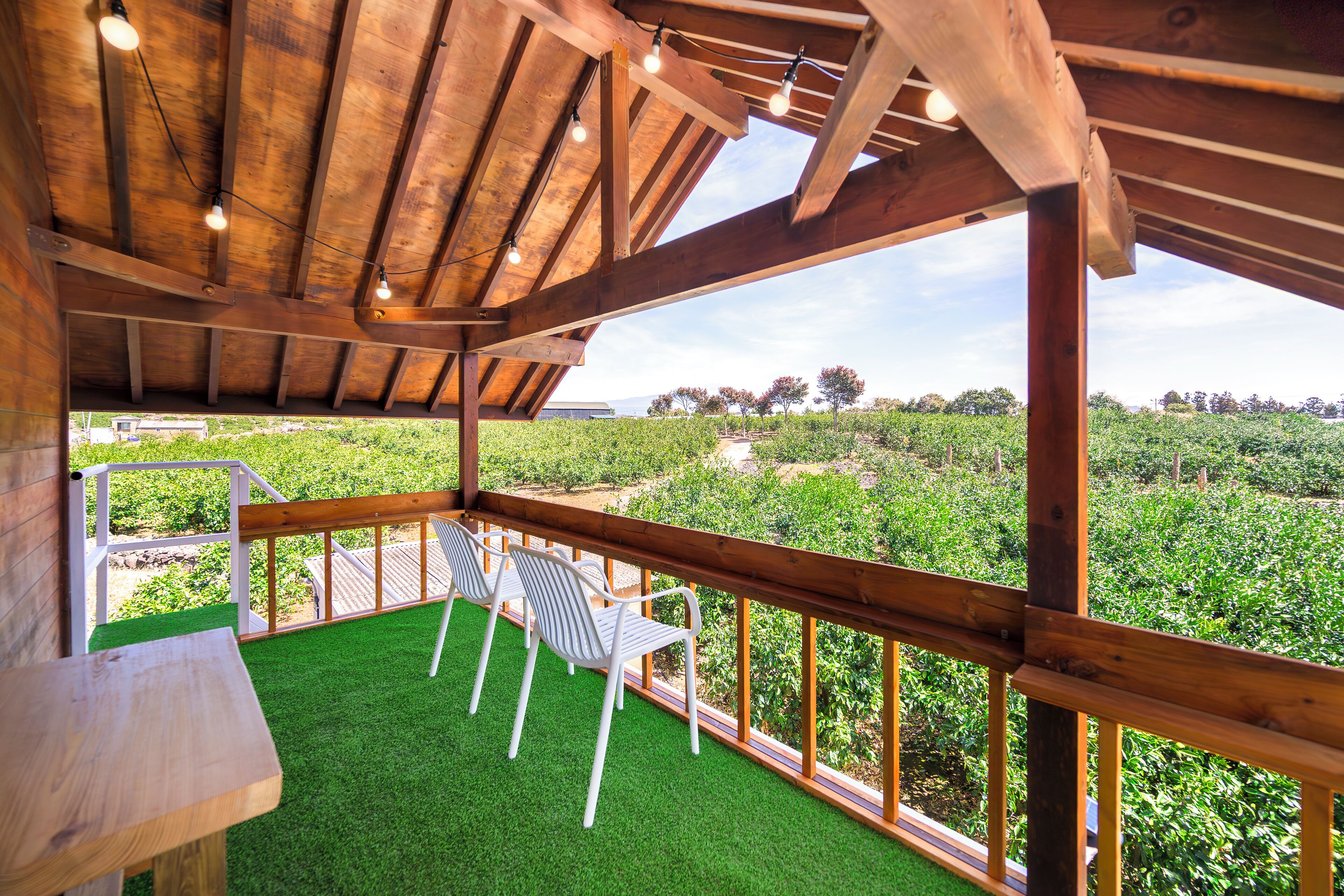 A wooden deck with a view of a vineyard.
