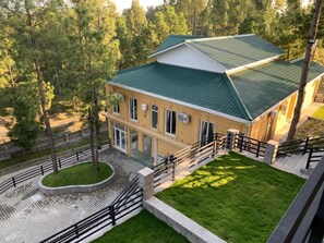 Un bâtiment à deux étages, doté d’un toit végétalisé et entouré d’arbres.