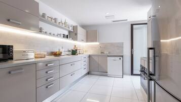 Een moderne keuken met een magnetron, broodrooster en koelkast.
