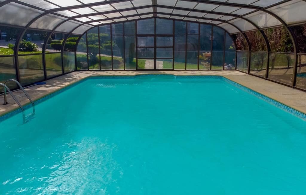 Una piscina al aire libre, sombrillas, tumbonas