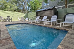 Une piscine avec des chaises longues et un espace abrité.