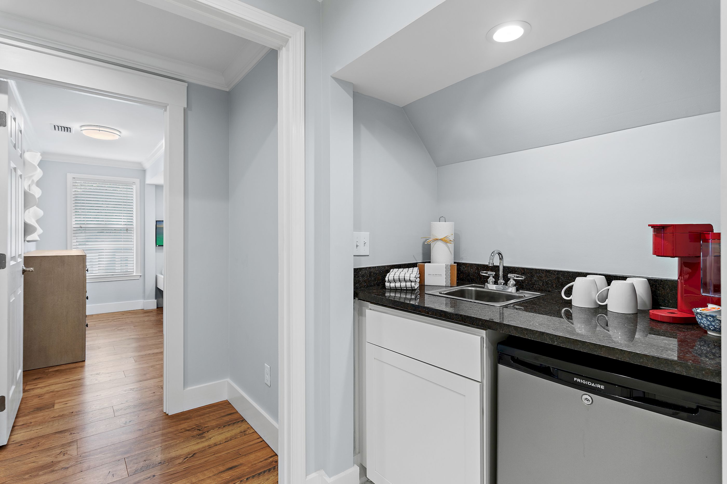 A modern kitchen with a dishwasher, a coffee maker, and a sink.