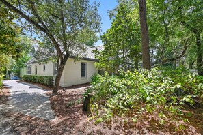 A residential area with a single-story house, a paved driveway, and surrounding greenery. - Adorable Old Seagrove Beach Cottage Bordering Seaside Near Beach Access (Santa Rosa Beach)