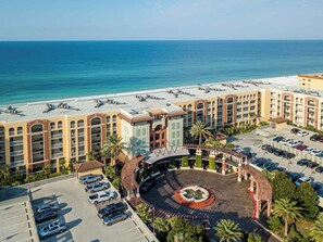 Ein Hotel mit Innenhof, mehreren Parkebenen und Blick auf den Strand.