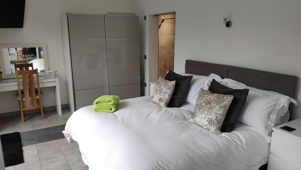 Ein Schlafzimmer mit Bett, Schreibtisch und Kleiderschrank.