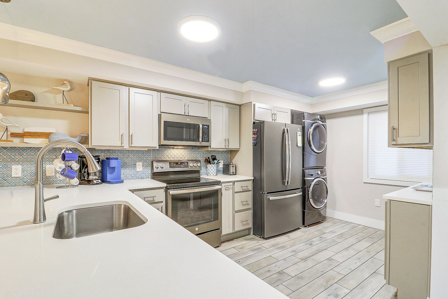 A modern kitchen with stainless steel appliances, a built-in oven, and a double-door refrigerator.