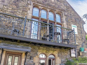 A stone building with a balcony, a 'TO LET' sign, and a 'Holiday Cottage' sign. - Hillside Cottage (Windermere)