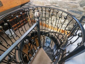 A spiral staircase with a metal railing and a wooden handrail. - Hillside Cottage (Windermere)