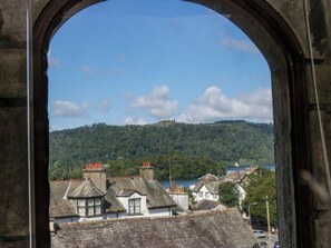 A view through an archway of a town with buildings and a hill in the background. - Hillside Cottage (Windermere)