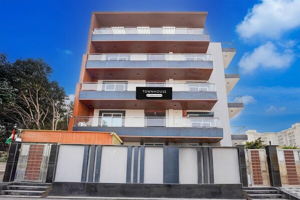 A multi-story building with a sign reading 'TOWNHOUSE.' - Deluxe With Balcony Viva Residency (Noida)