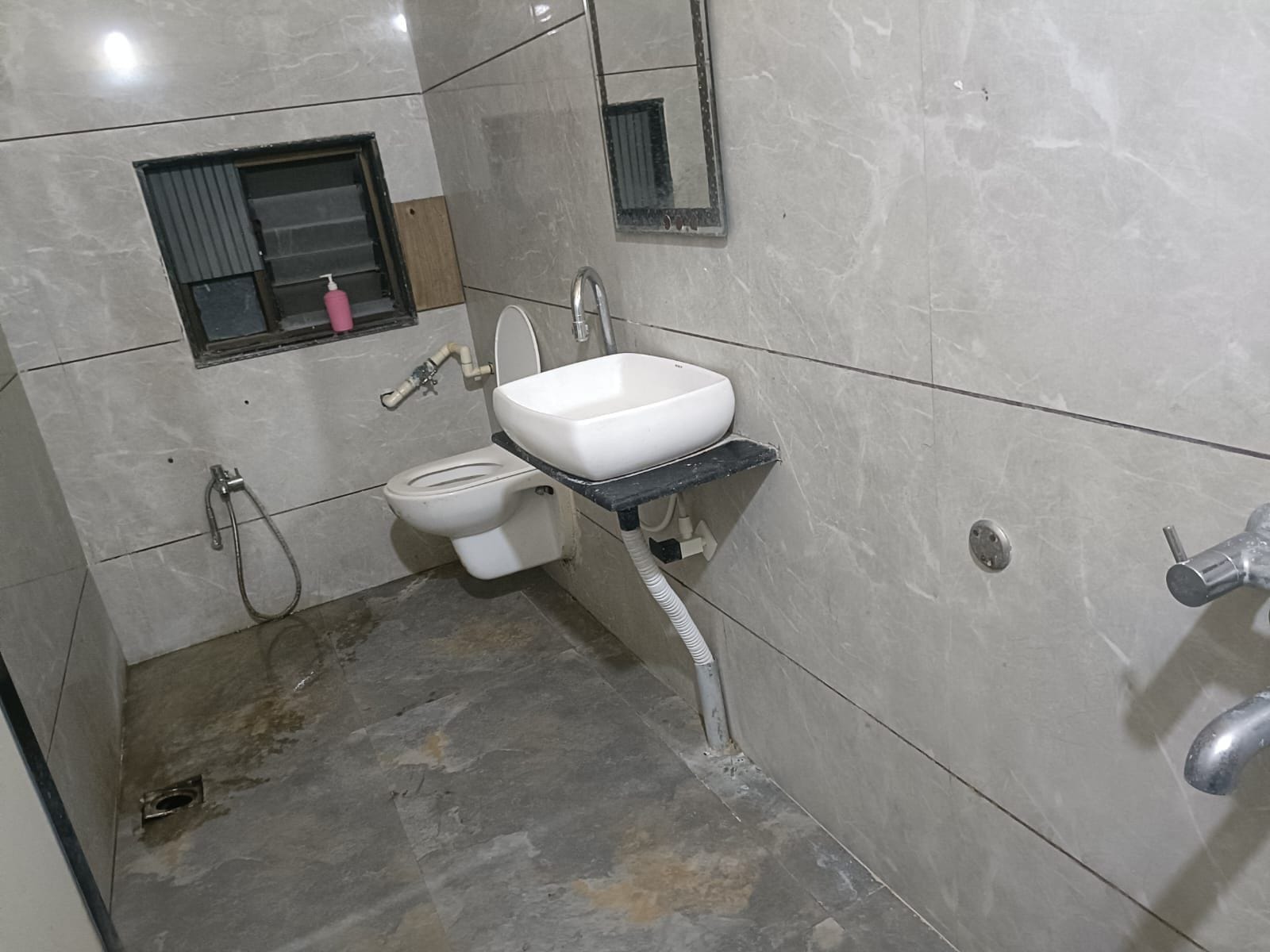 A bathroom with a toilet, sink, and shower.