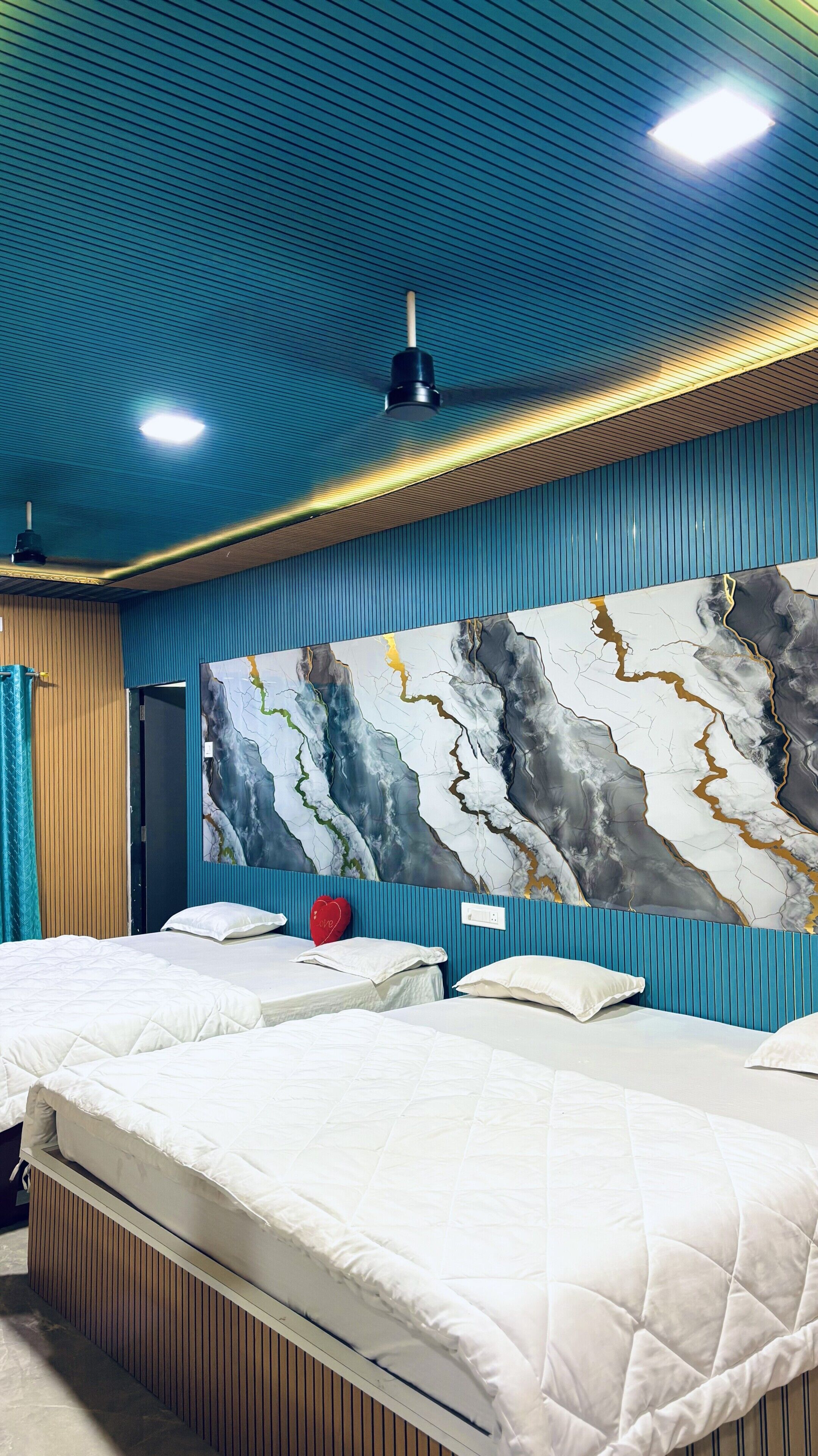 Quarto de hotel com uma cama grande, uma obra de arte na parede e um ventilador de teto.
