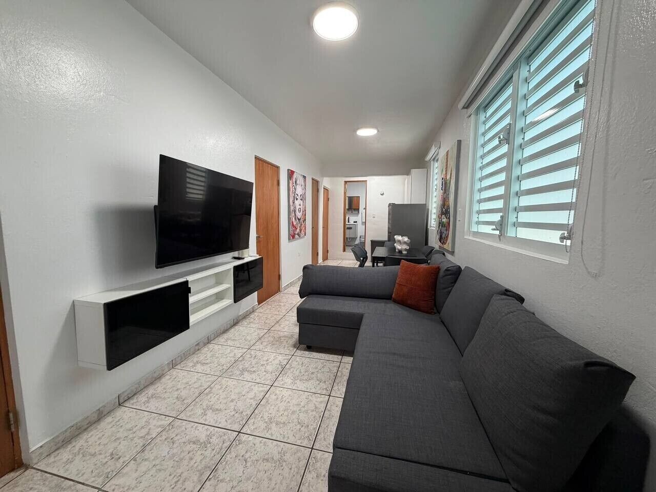 Ein Wohnzimmer mit Fernseher, Sofa und einem kleinen Tisch.