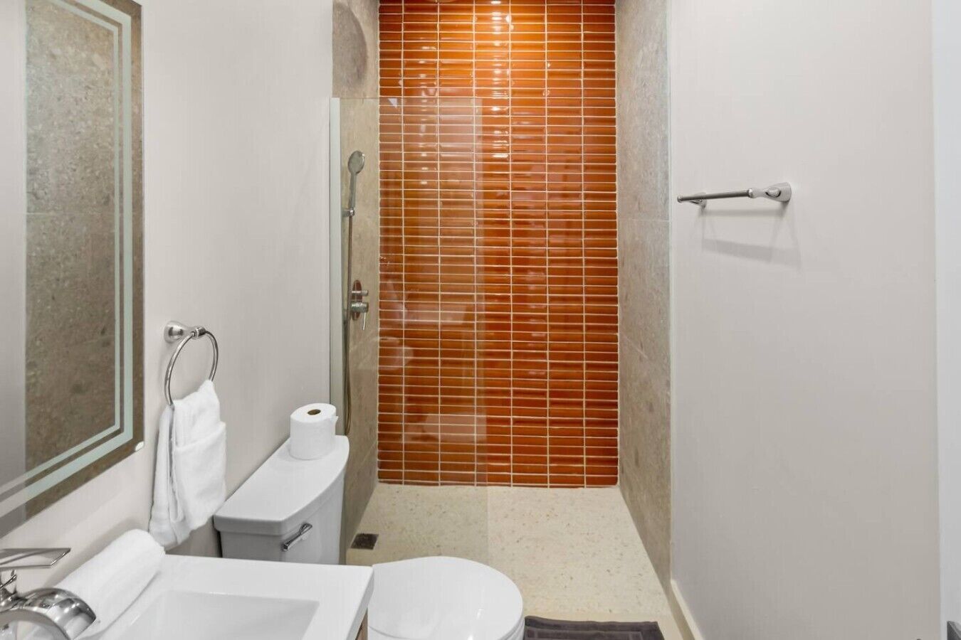 A bathroom with a toilet, sink, and shower.