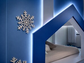 En modern inredning med ett geometriskt mönster, en snöflingsdekoration och en säng med utsikt in i ett annat rum.