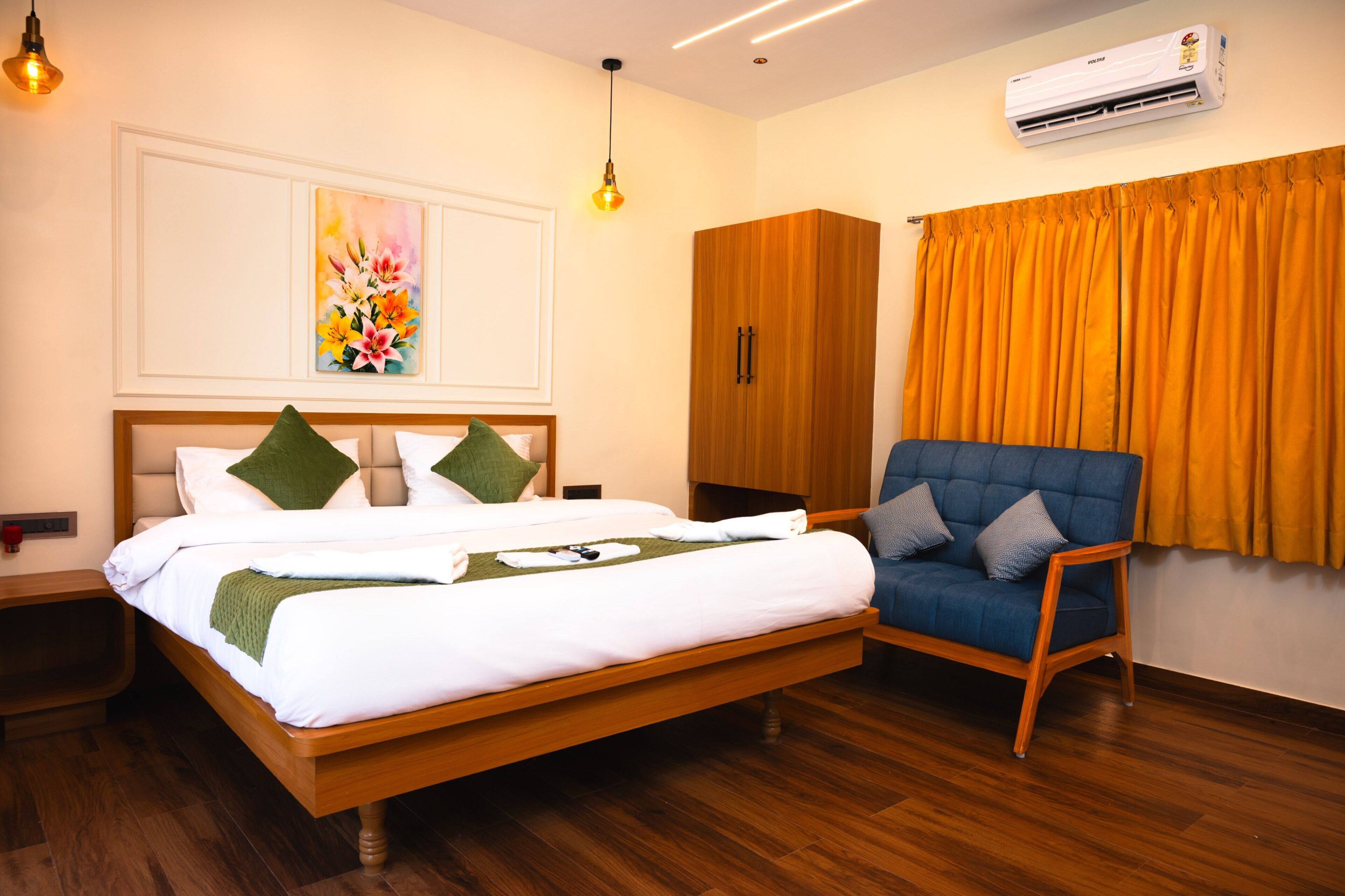 Une chambre d’hôtel avec un lit, une chaise, un climatiseur et un tableau au mur.