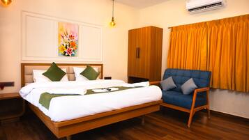 Une chambre d’hôtel avec un lit, une chaise, un climatiseur et un tableau au mur.