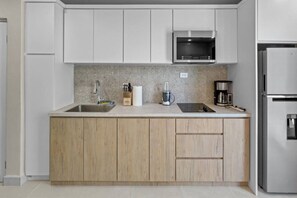 A modern kitchen with a stainless steel refrigerator, a microwave, and a coffee maker. - Costa Brava Apt 2 | Calle Loiza 2 Bed @ San Juan (San Juan de Puerto Rico)