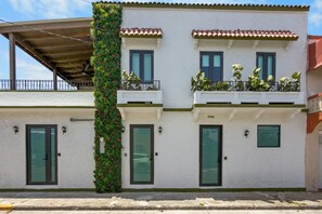 A two-story building with a balcony on the upper floor, a green vertical garden on the left, and a number '2009' on the facade. - Costa Brava Apt 2 | Calle Loiza 2 Bed @ San Juan (San Juan de Puerto Rico)