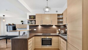 Une cuisine moderne avec des meubles en bois, un four encastré et un plan de travail.