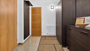 Un couloir avec des armoires en bois et en bois foncé, un radiateur et une carte encadrée accrochée à une armoire.