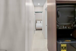 A hotel corridor with a bed, a television, and a sign indicating energy usage. - Costa Brava Apt 3 | Calle Loiza 1/1 @ San Juan (San Juan de Puerto Rico)