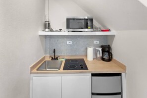 A compact kitchenette with a microwave, a coffee maker, and a sink. - Costa Brava Apt 3 | Calle Loiza 1/1 @ San Juan (San Juan de Puerto Rico)