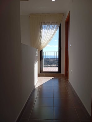 Ein Flur, der zu einem Balkon mit Blick auf die Landschaft führt.