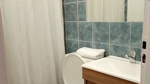 Ein Badezimmer mit Toilette, Waschbecken und Duschvorhang.