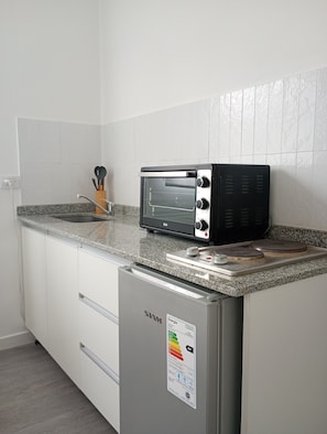 A kitchen with a built-in toaster oven, a granite countertop, and a stainless steel refrigerator. - Acogedor departamento en Villa Urquiza (Buenos Aires)