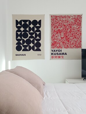 A bedroom with a bed, a TV, and two posters on the wall. - Acogedor departamento en Villa Urquiza (Buenos Aires)