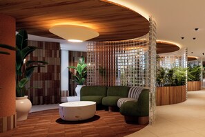 Un interior moderno con un techo de madera curvada, una zona de estar con un sofá y reposapiés verdes, y un separador decorativo de vidrio.