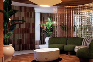 A modern interior with a wooden floor, a green sofa, a white round table, and a potted plant. - Aura By Aubamar (Palma de Mallorca)