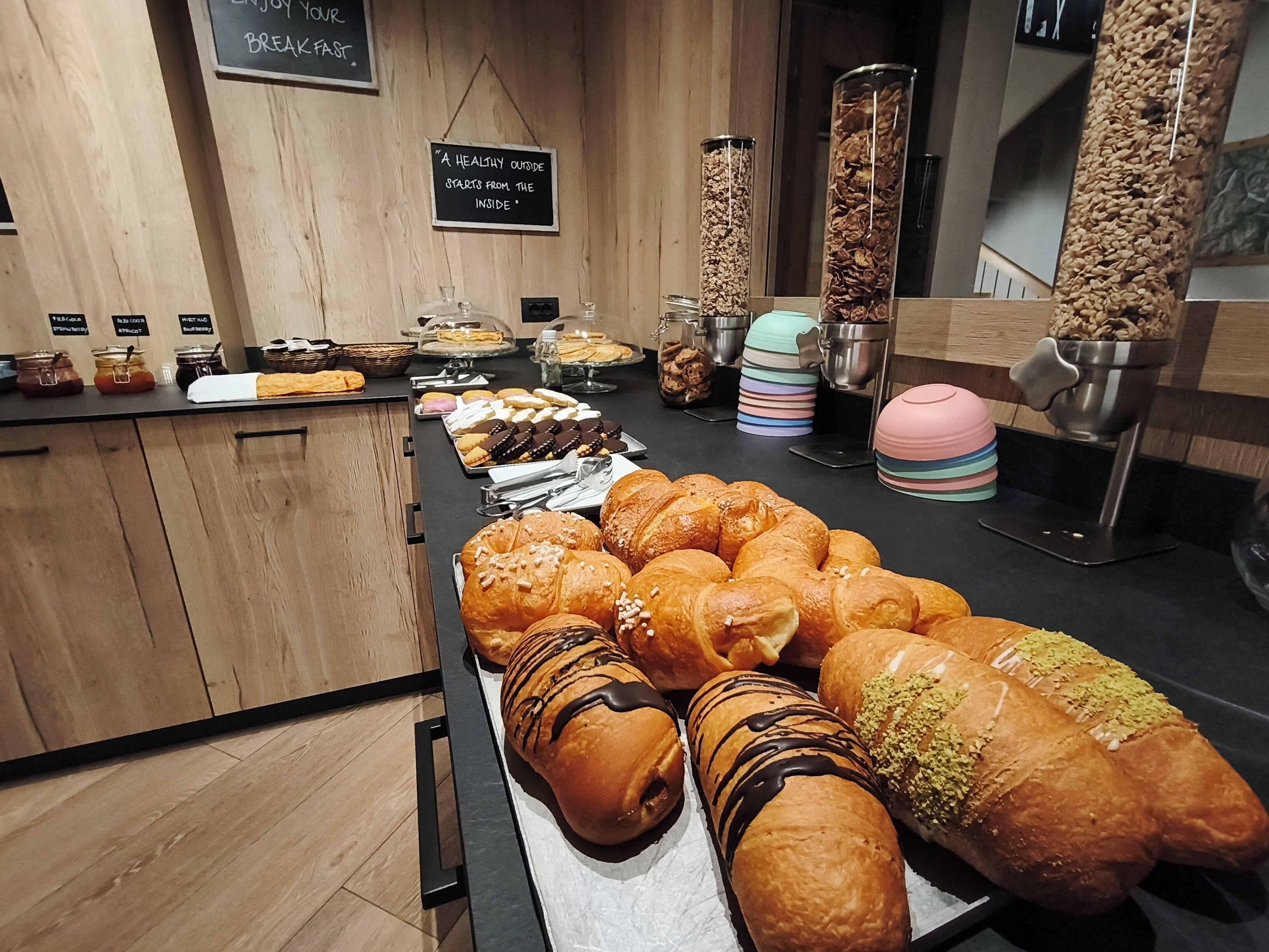 A breakfast buffet with various pastries and a sign stating 'A healthy outside starts from the inside.'