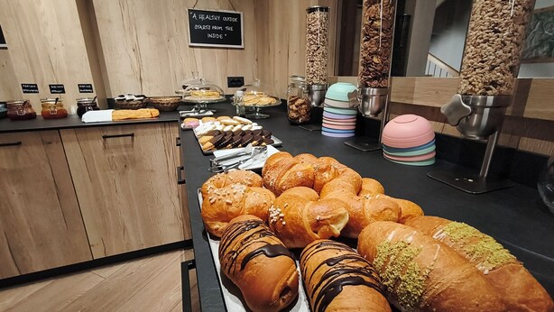 A breakfast buffet with various pastries and a sign stating 'A healthy outside starts from the inside.' - Steinbock B&B (Livigno)