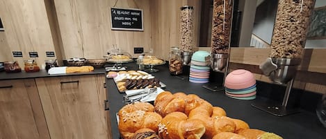 A breakfast buffet with various pastries and a sign stating 'A healthy outside starts from the inside.'