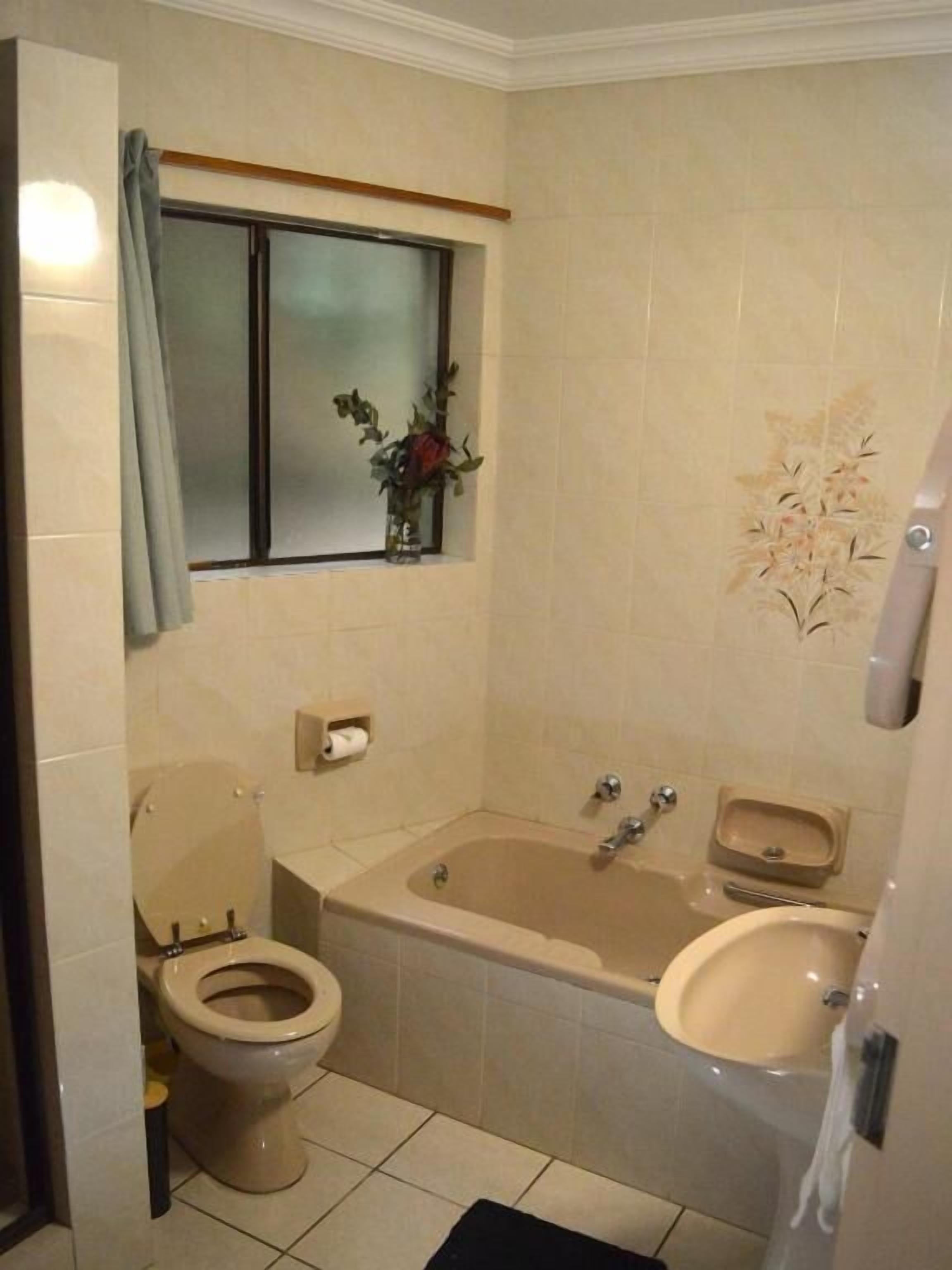 A bathroom with a toilet, bathtub, and sink.